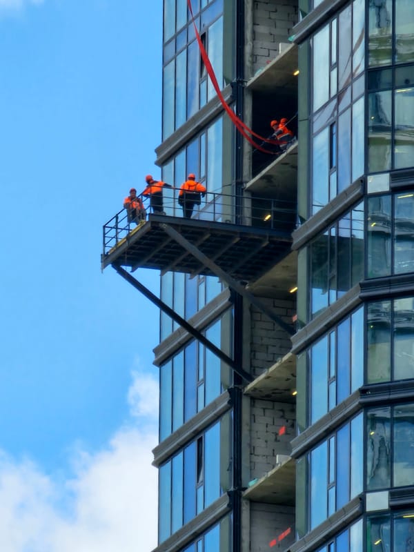 Moscow high-rise construction site, workers on exterior facades