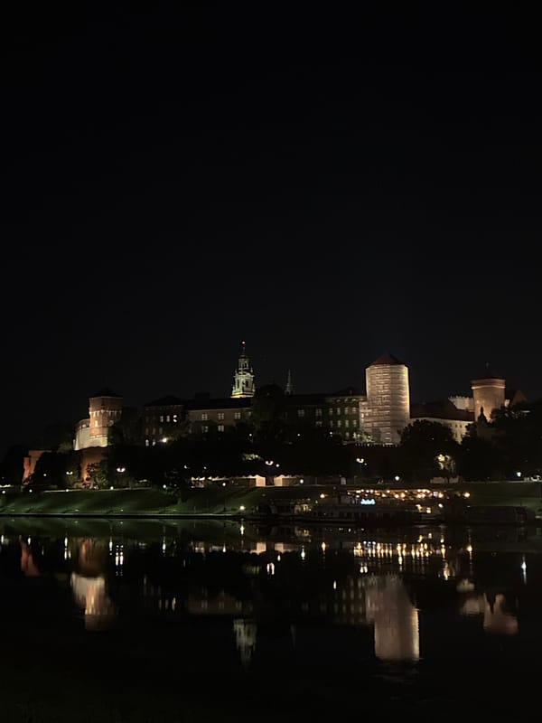 Wawel Castle glowing over the Vistula on a Krakow night