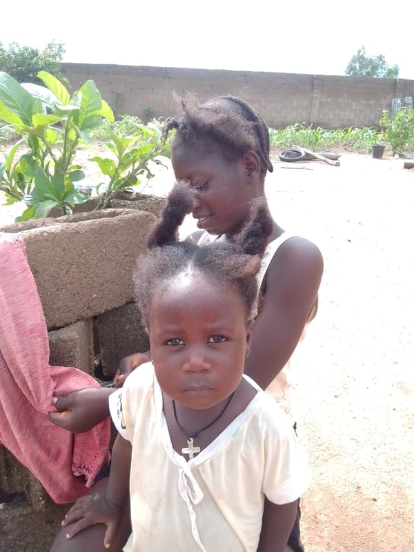 Everyday life in a rural Nigerian compound on a cloudy afternoon