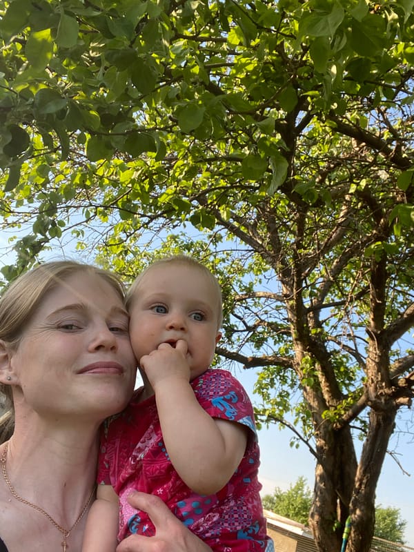 Woman holds baby outdoors in Кукуи, Russia