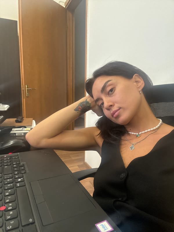 Seated in a Tbilisi office, layered necklaces, two angles