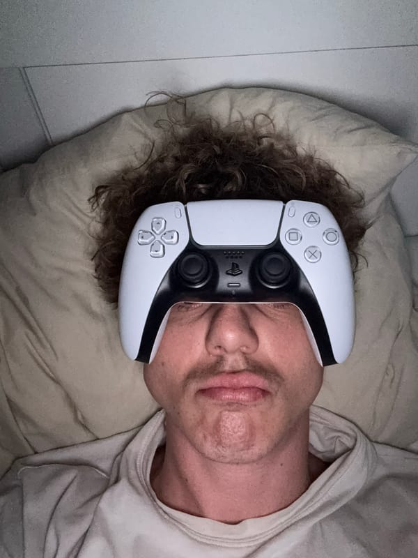 Person plays with PlayStation controller while lying in bed