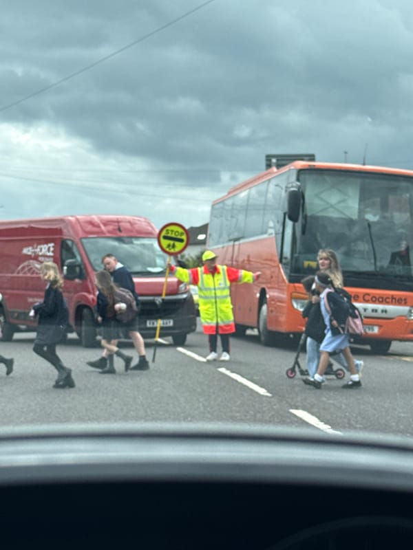 School crossing guard helps children cross street in Great Yarmouth