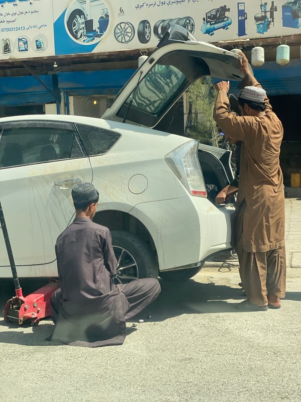 Roadside car repair underway on a Kandahar street