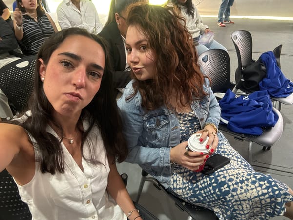 Two women photographed indoors, one in denim jacket
