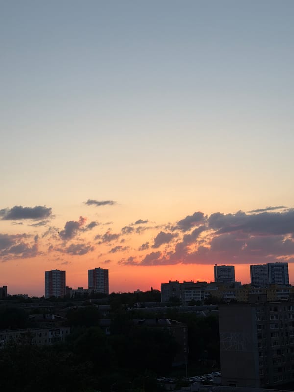 Sunset paints city sky in orange and pink hues