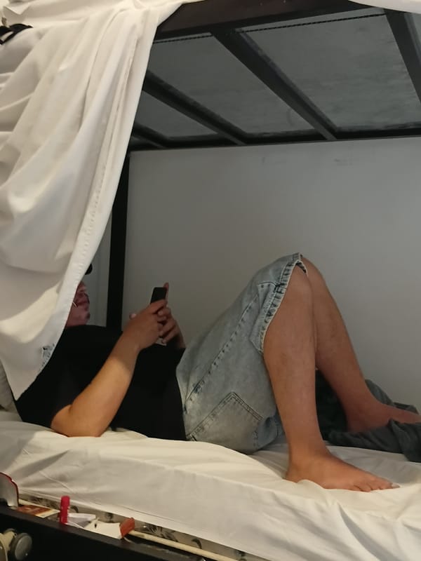 Person uses phone while lying upside down on bed