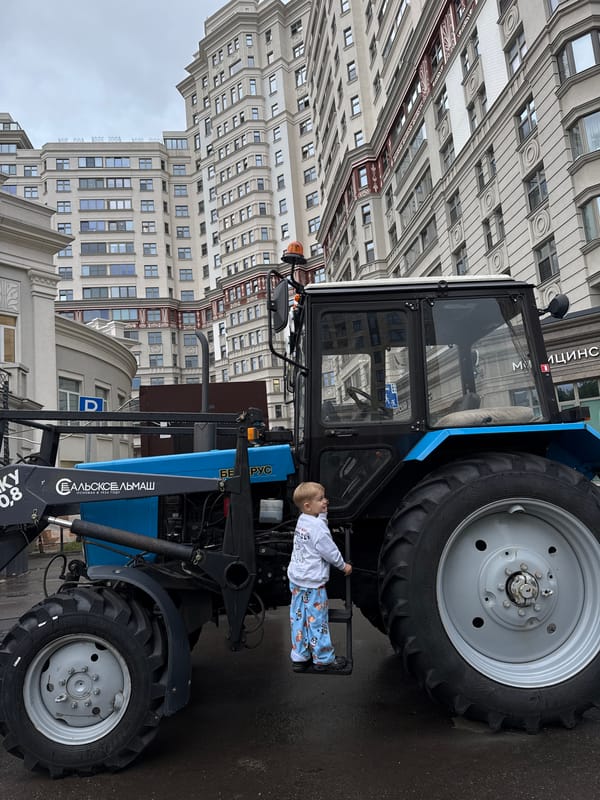 Kid explores parked municipal vehicles on a Moscow street