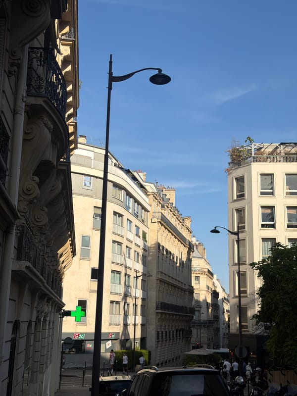 Parisian streets, stone facades, and a sidewalk cafe on a summer afternoon