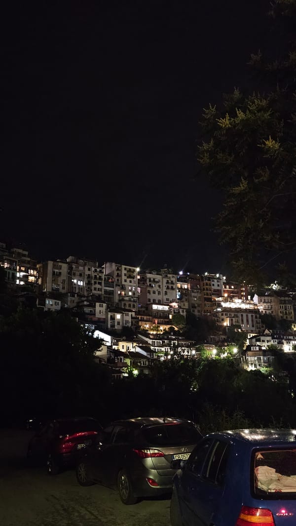 Nighttime urban hillside scene documented with illuminated buildings