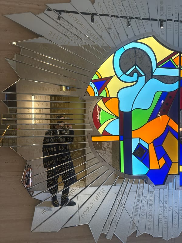 London indoor display features stained glass, visitor with beverage