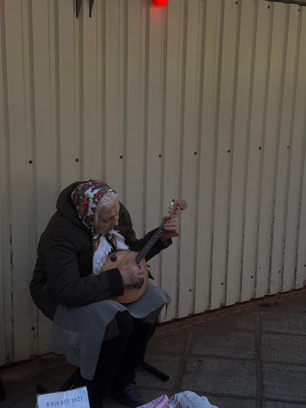 Elderly street musician performs with domra in central Moscow