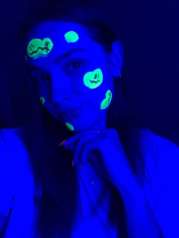 Woman documents blacklight face paint session in Noviy Russia