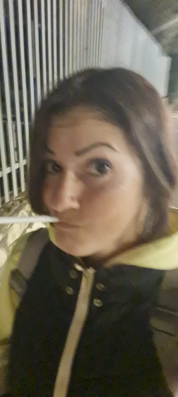 Woman takes selfie, cigarette lit in Nahariyya evening scene