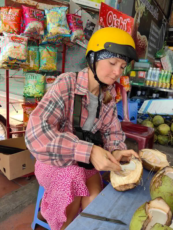 Tourists enjoy fresh coconuts at Vietnam street café