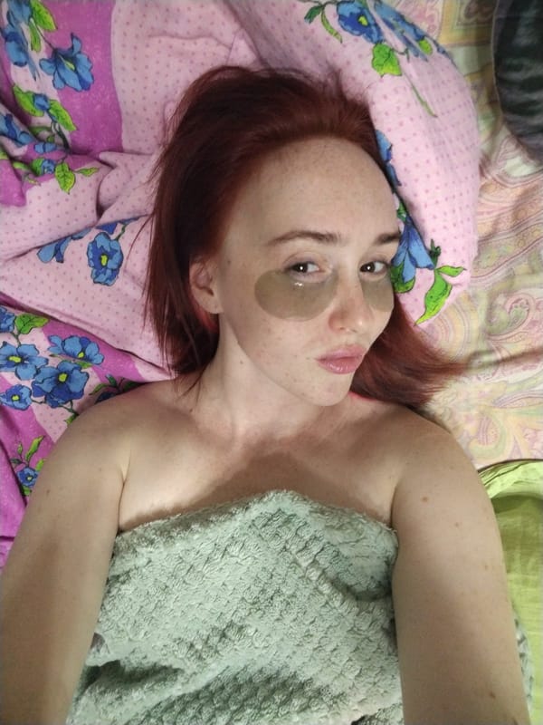 Woman rests with eye patches, cat pillow in Izhevsk