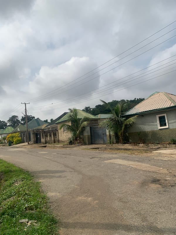Morning foot traffic through a residential Abuja neighborhood