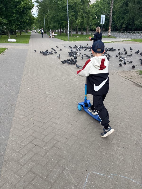 Child with Patriots cap plays with scooter in Russian park
