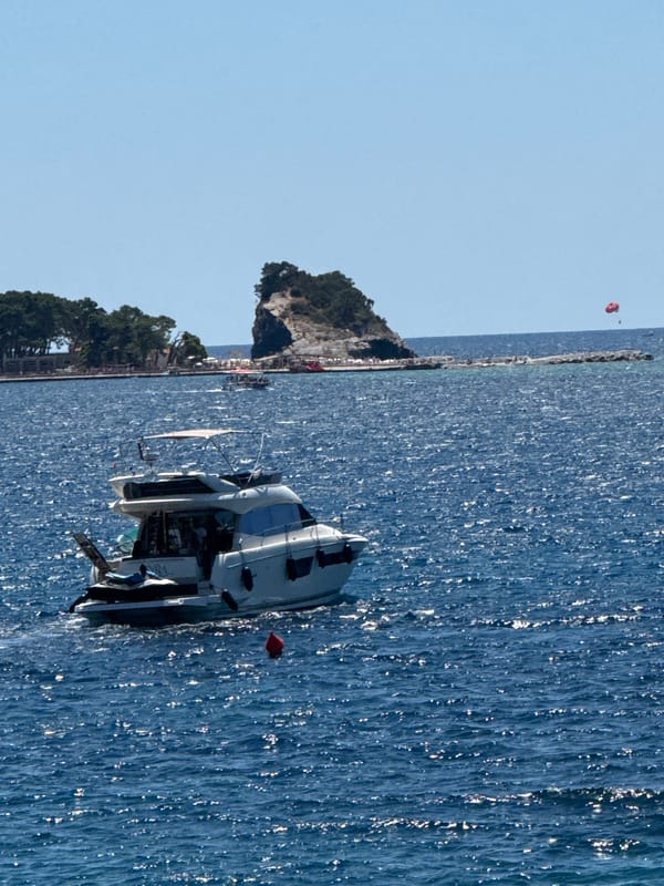 Yacht and paddleboarders on the Budva coast