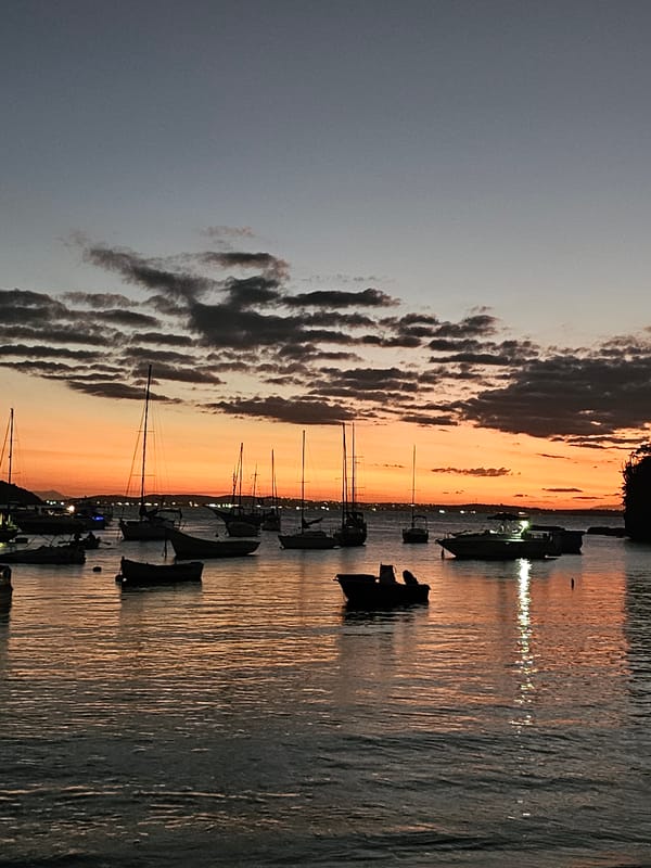 Sunset illuminates sailboats in Armação Dos Búzios harbor