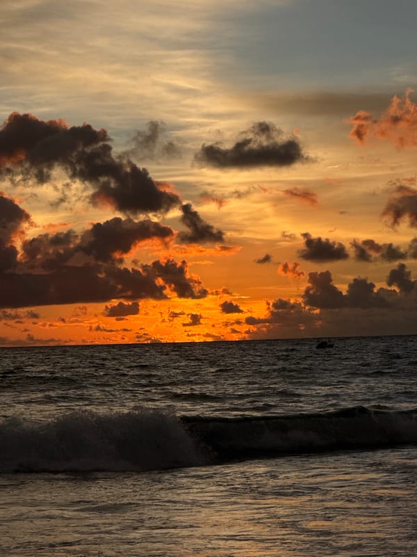 Sunset hour at Karon Beach — parasailing, crowds, vivid skies
