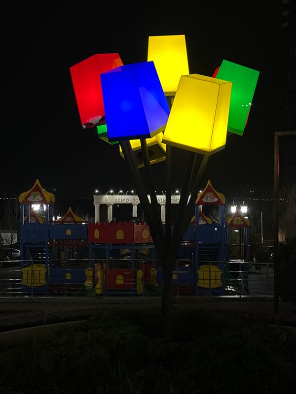 Illuminated playground and vintage streetlights captured at night in Rostov-on-Don