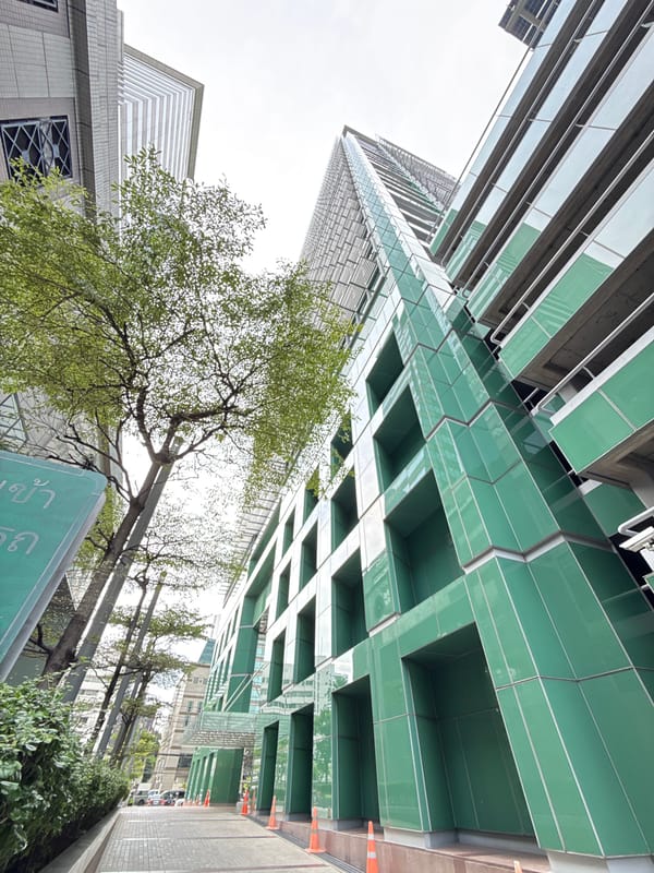 Street-level Bangkok: skywalks, delivery riders, and modern towers
