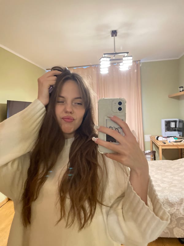 Woman takes selfies while styling hair in Ufa residence