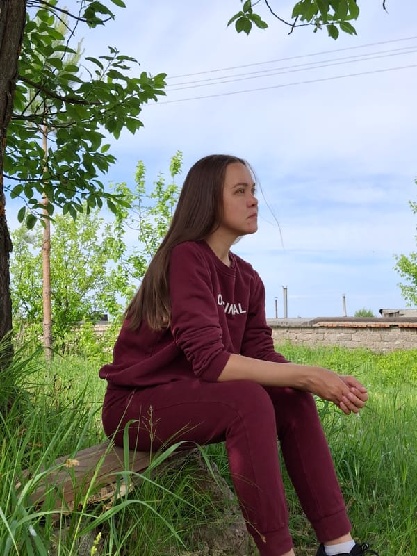 Woman in tracksuit cycles dirt path in Chaikovsky