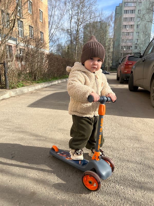 Mother and child enjoy morning scooter ride in Russian park