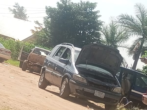 Disabled minivan with hood open spotted on Nigeria dirt road