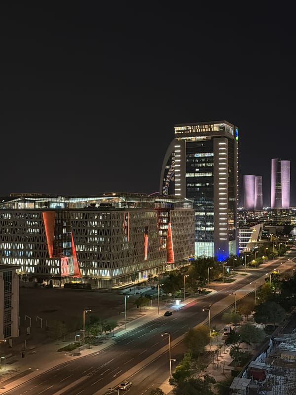 Illuminated waterfront Ferris wheel observed across modern cityscape