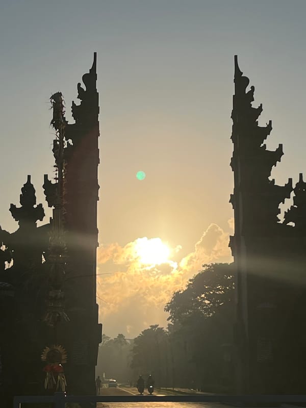 Balinese split gate silhouetted against a golden sky