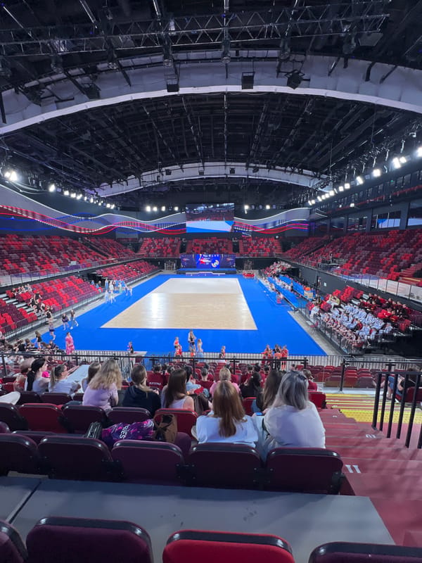 Young gymnasts perform synchronized routine in indoor arena
