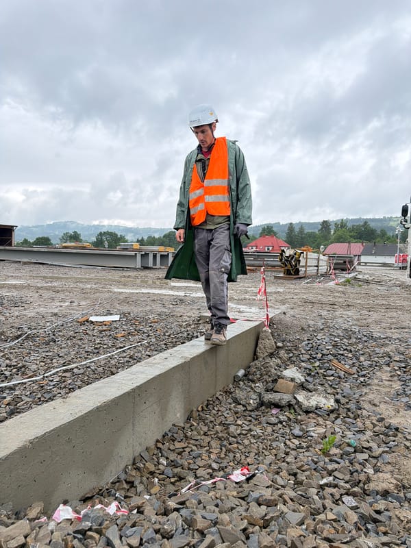 Construction crew works under cloudy skies in rural Poland