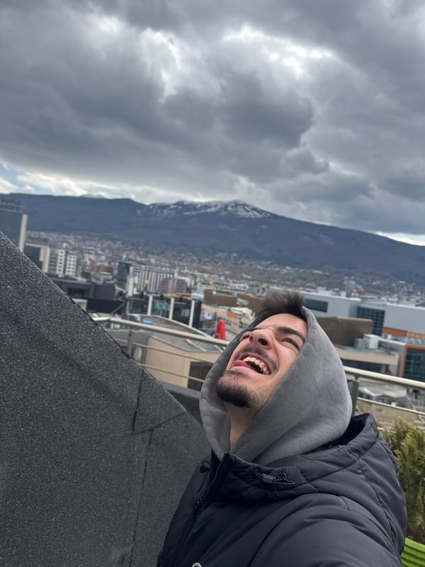 Man takes rooftop selfies overlooking Sofia cityscape