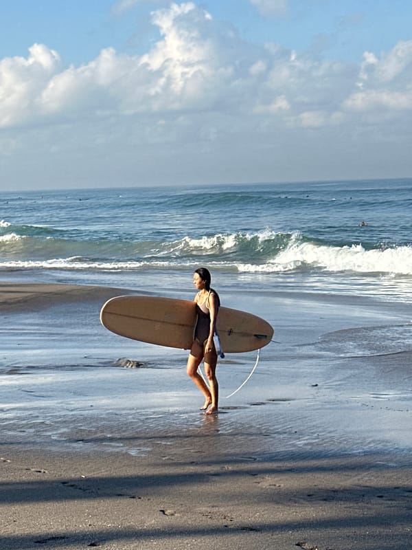 Surfers and beachgoers on a lively North Kuta shoreline