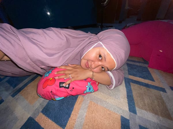 Young woman in hijab photographed reclining indoors in Gelam