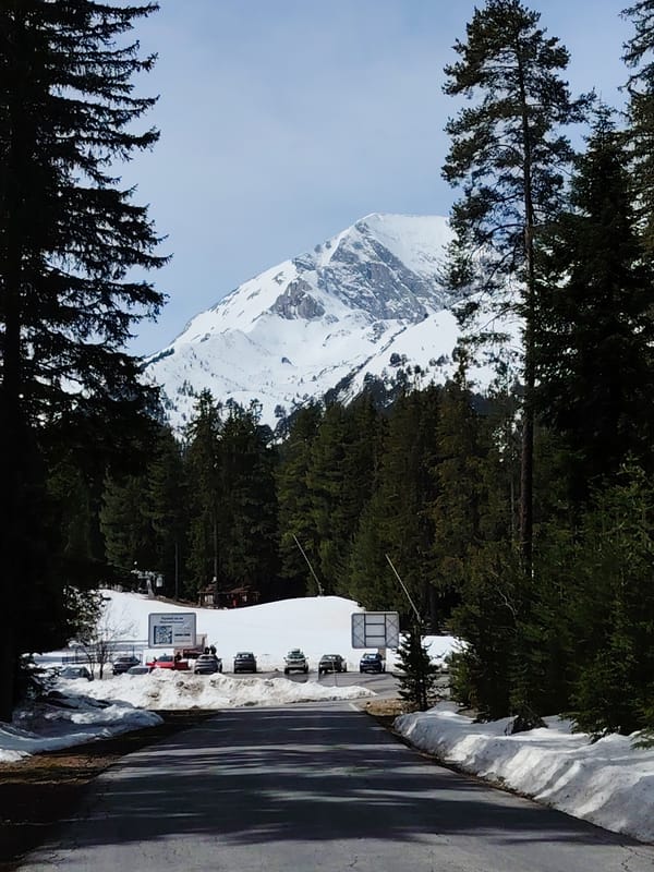 Clear skies frame snow-capped mountains in Bansko, Bulgaria