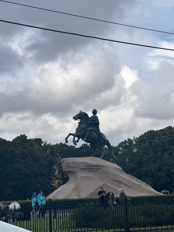 Cloudy day on a Russian city riverfront with bridge and statue