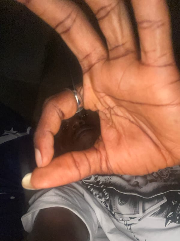 Person handles skincare lotion during evening routine in Lokoja