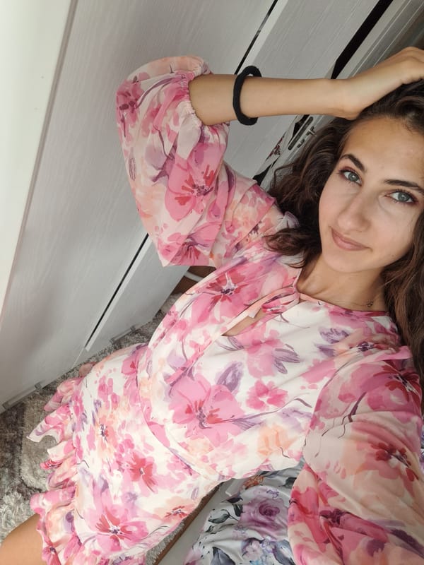 Pink dress, cozy indoor setting, and a flowering cactus