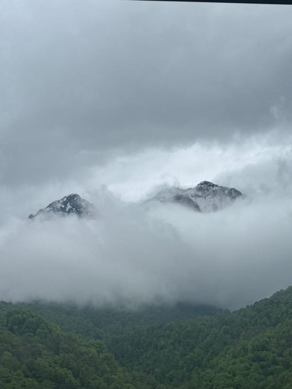 Fog shrouds snowy mountain peaks in Krasnaya Polyana, Russia