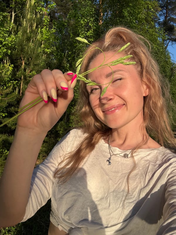 Woman relaxes outdoors as hand gesture frames sun in Noviy
