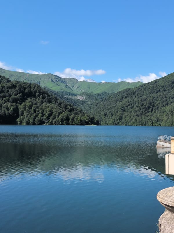 Glassy mountain lake reflects forested hills in rural Azerbaijan