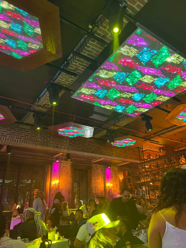 Packed NYC club night with laser lights and LED ceiling panels