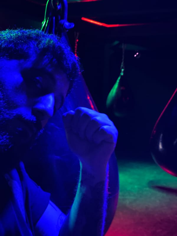 Man with tattoos photographed under colored lighting in Strasbourg