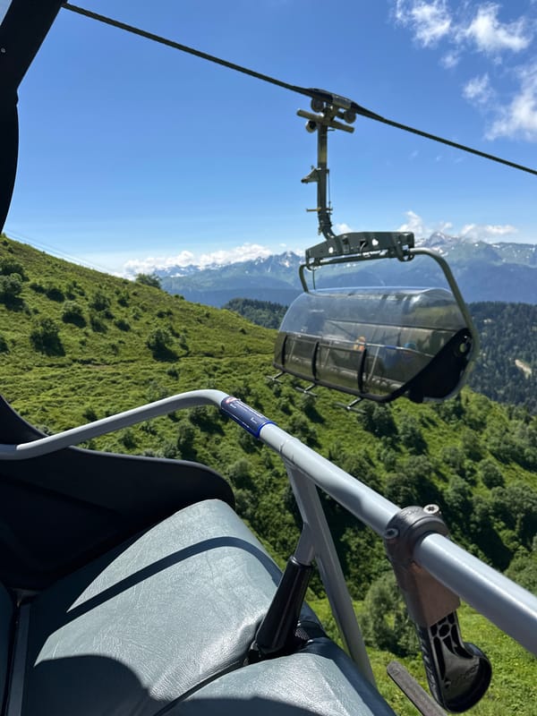 Summer ski lift ride through Estosadok's green mountain terrain