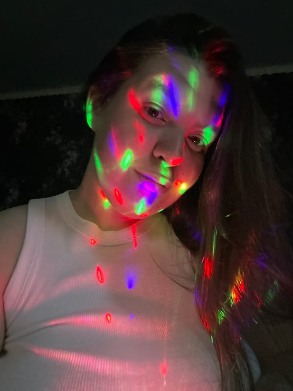 Person photographed under colorful projected lights in Russian town