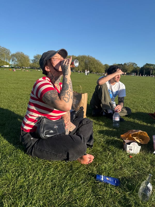 Two people enjoy sunny afternoon in London park